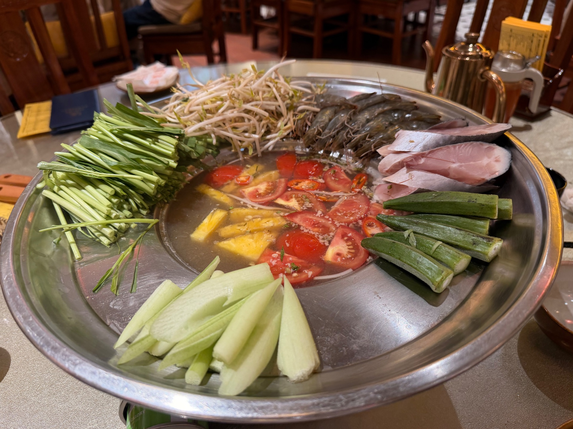 鍋の周縁が皿のように広がっており、そこにエビや野菜など食材が並んでいる