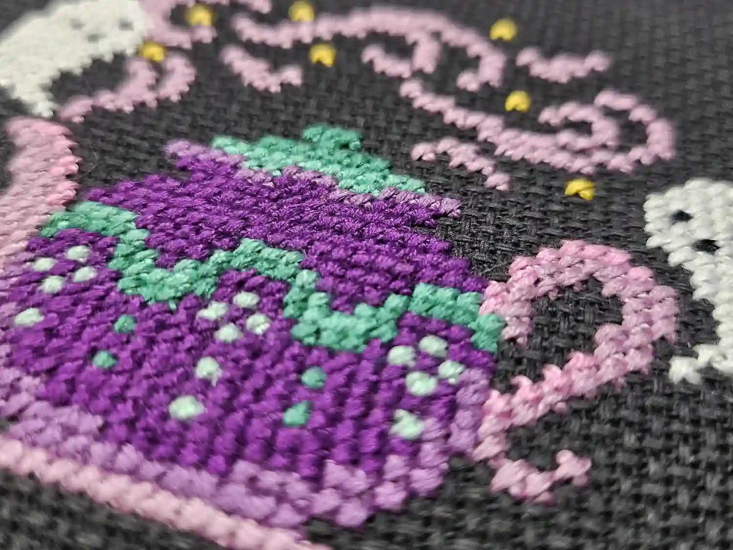 A close up of the decorations on the purple teapot.