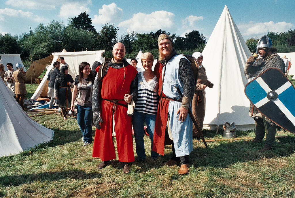 My mum between two men cosplaying as Knights during a medieval battle reenactment.