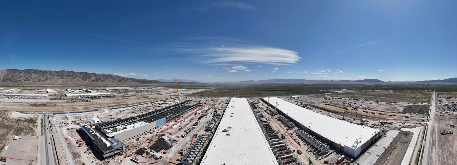 A panoramic shot of the same site, showing all three buildings under construction