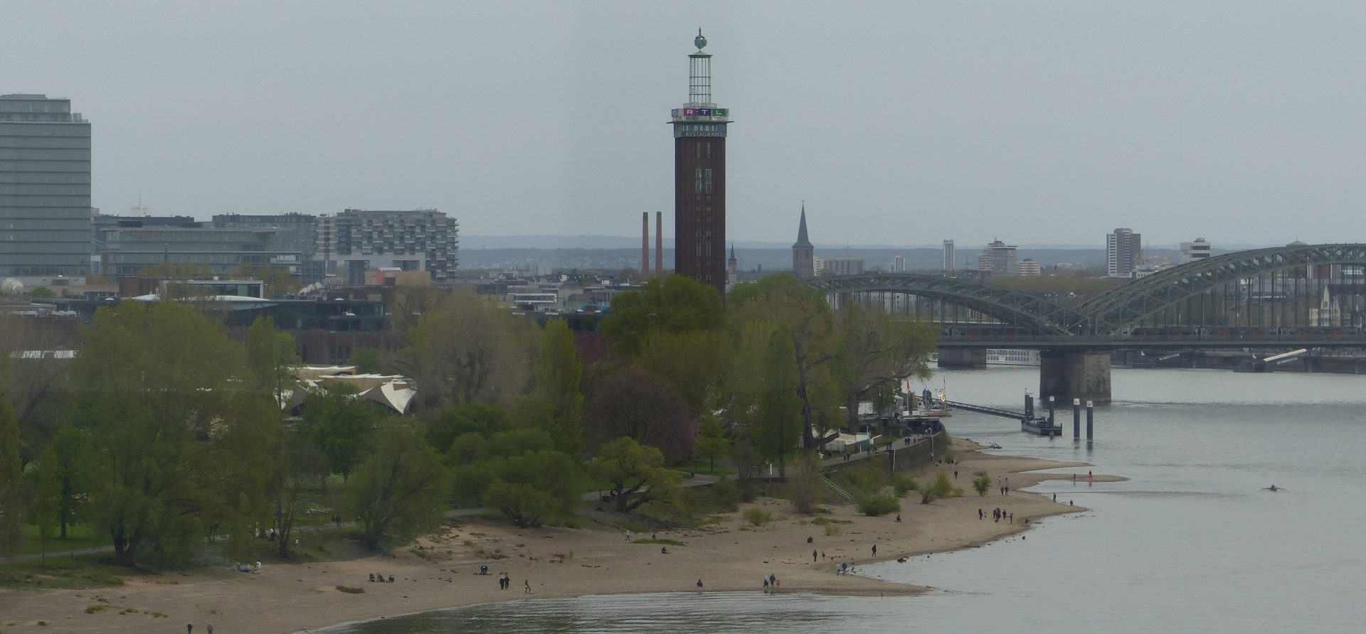Blick auf das rechtsrheinische Köln mit Rheinpark, Rhein, RTL-Turm und Hohenzollernbrücke.