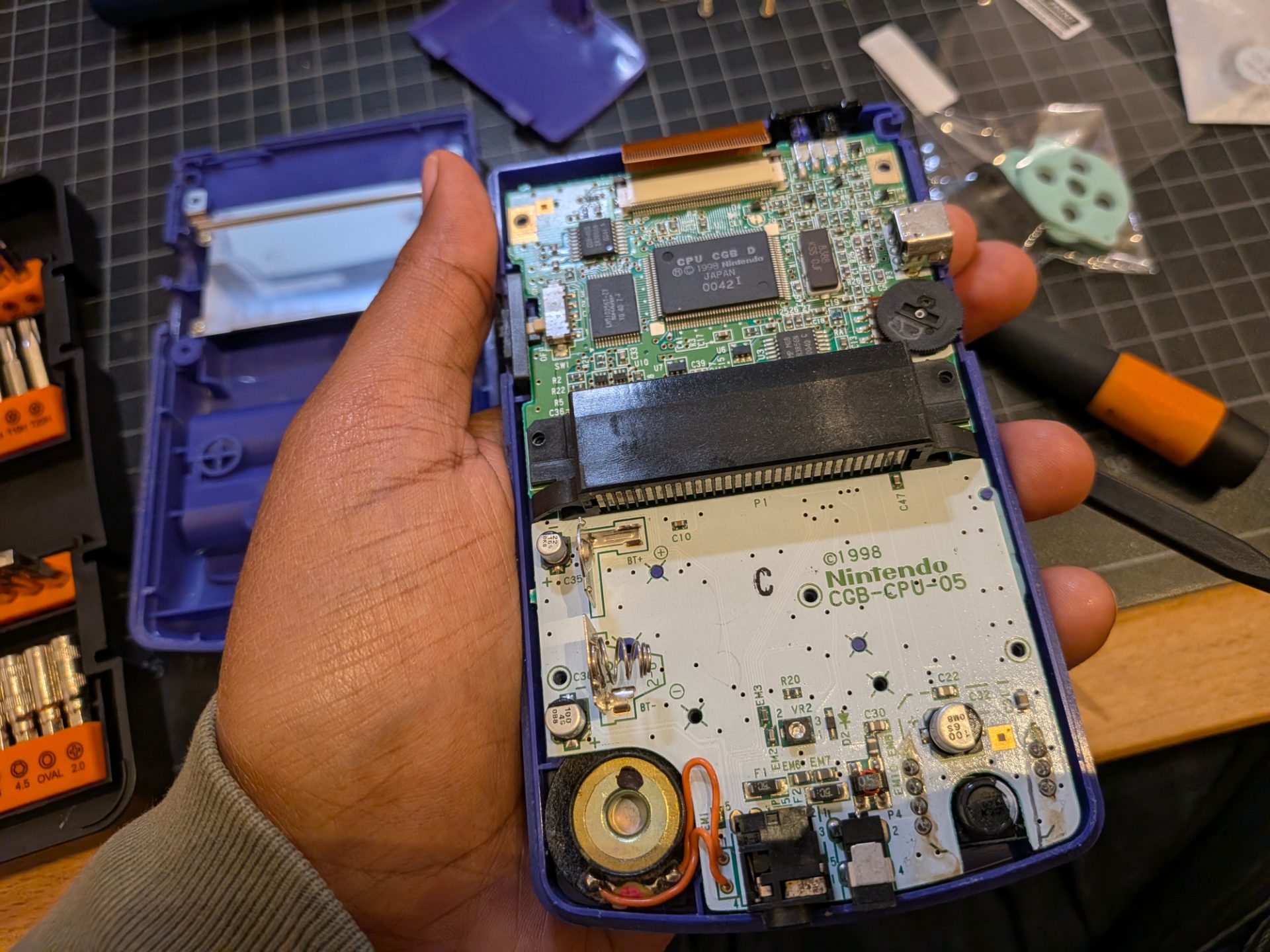 Holding the top half or the body with circuit board to show the speaker