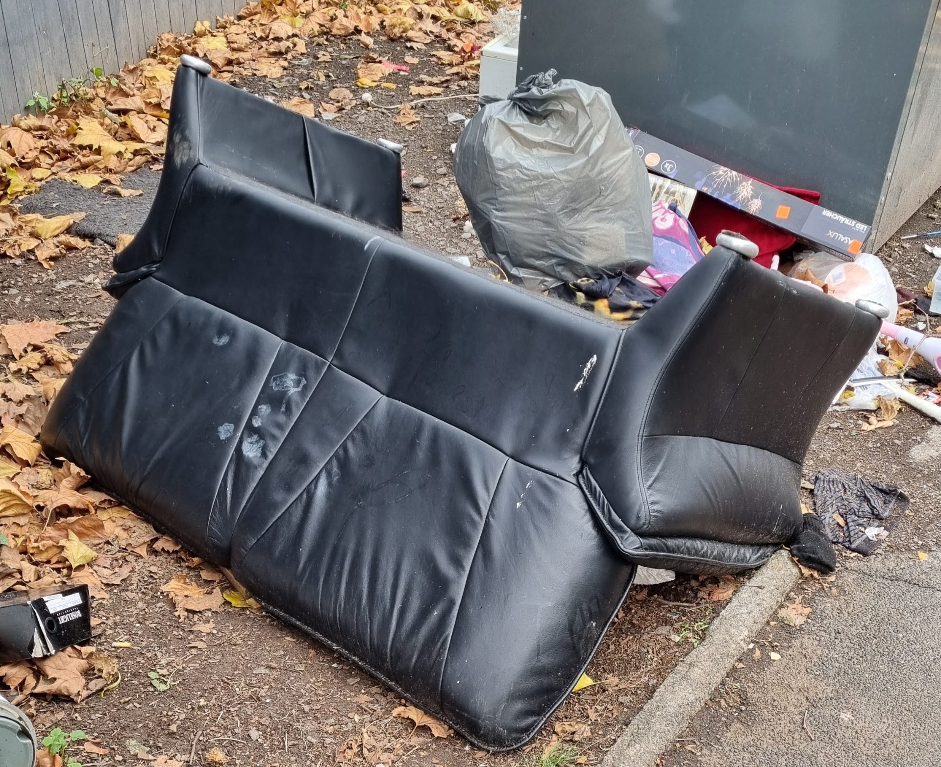 Wilder Müll vor einem Altkleidercontainer.