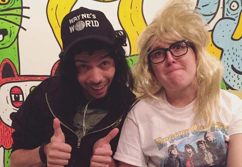 photo of juan as wayne and me as garth from waynes world, and there's a colorful illustrative mural behind us