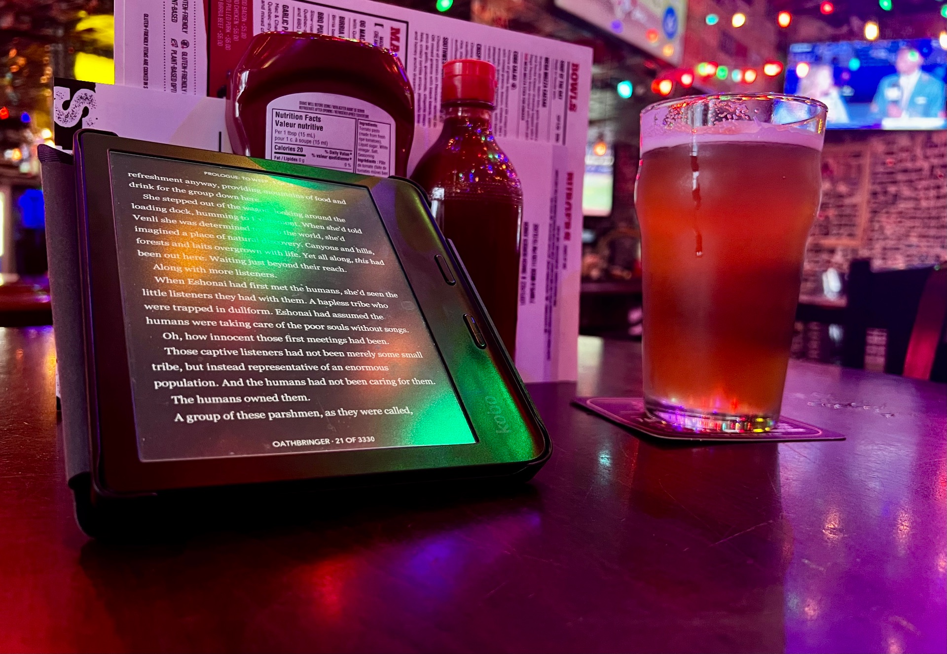 Oathbringer on Kobo, pint of sunsetter beer on the table in a pub