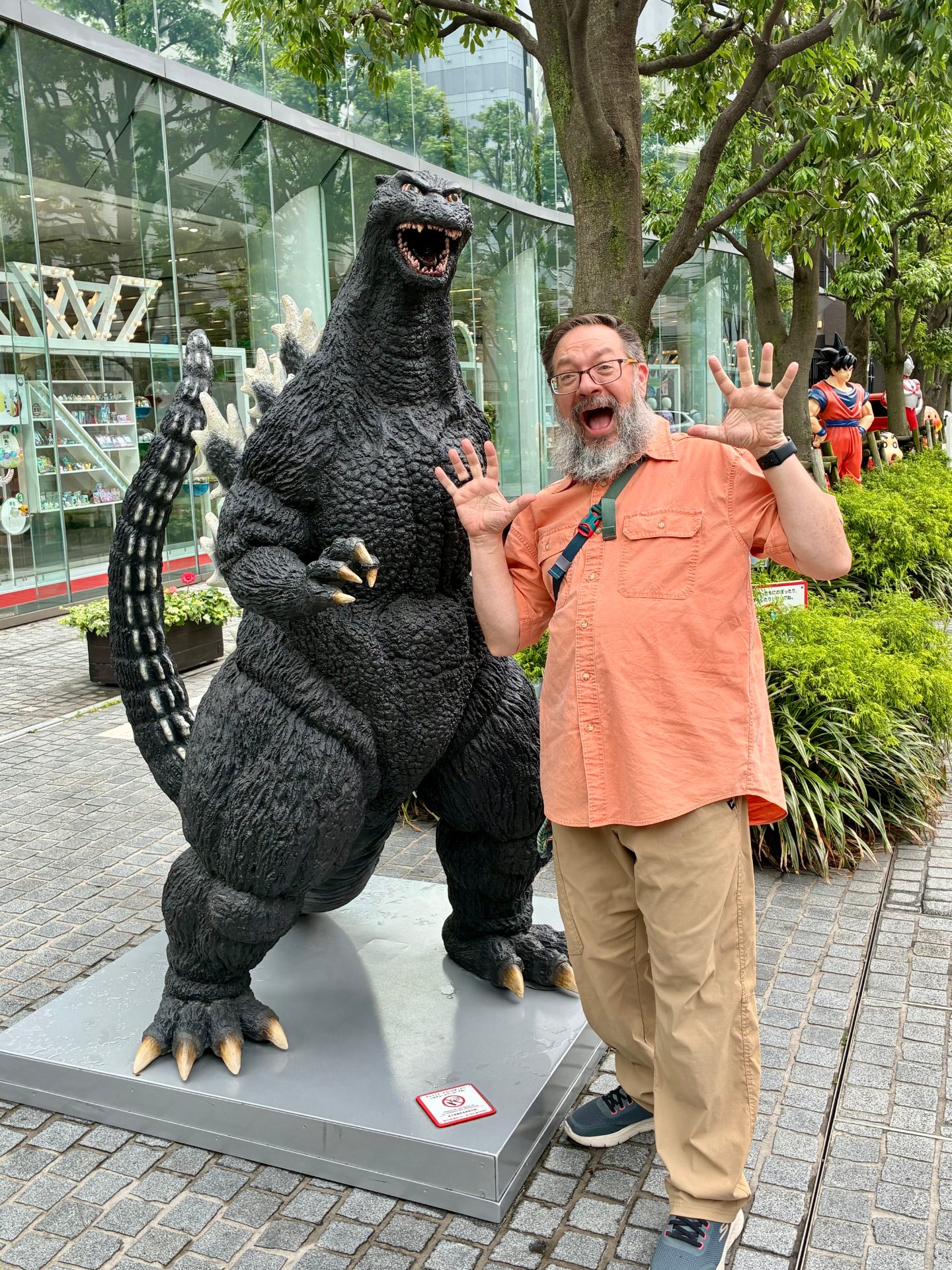 Me being very silly in front of a small-ish statue of Godzilla on a sidewalk in Japan. It was in front of a Bandai museum sorta place.