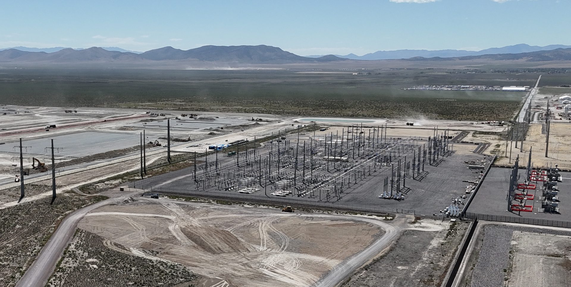 An aerial shot of a very large electrical substation. Transmission lines come in from the left, and attach to circuit breakers, bus bars, transformers, and other equipment.