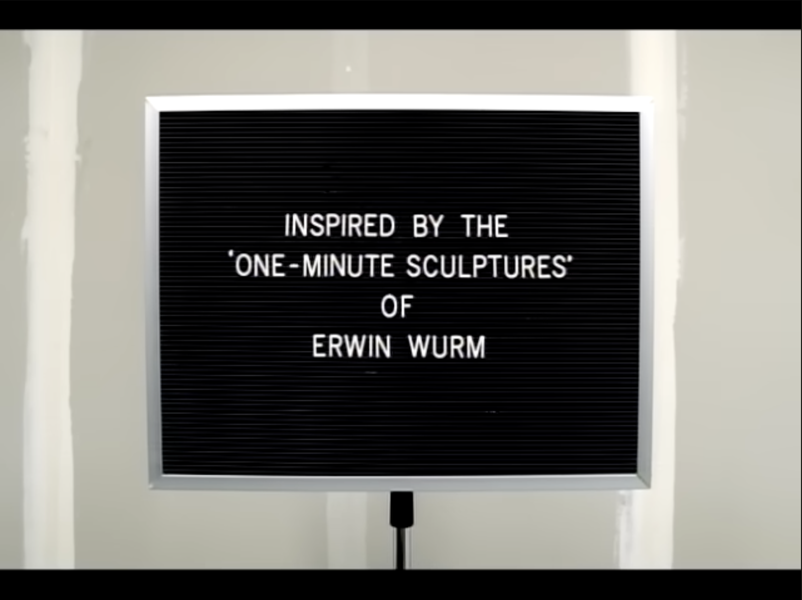 closing scene of the "can't stop" video that has a sign that says "INSPIRED BY THE 'ONE-MINUTE SCULPTURES' OF ERWIN WURM"