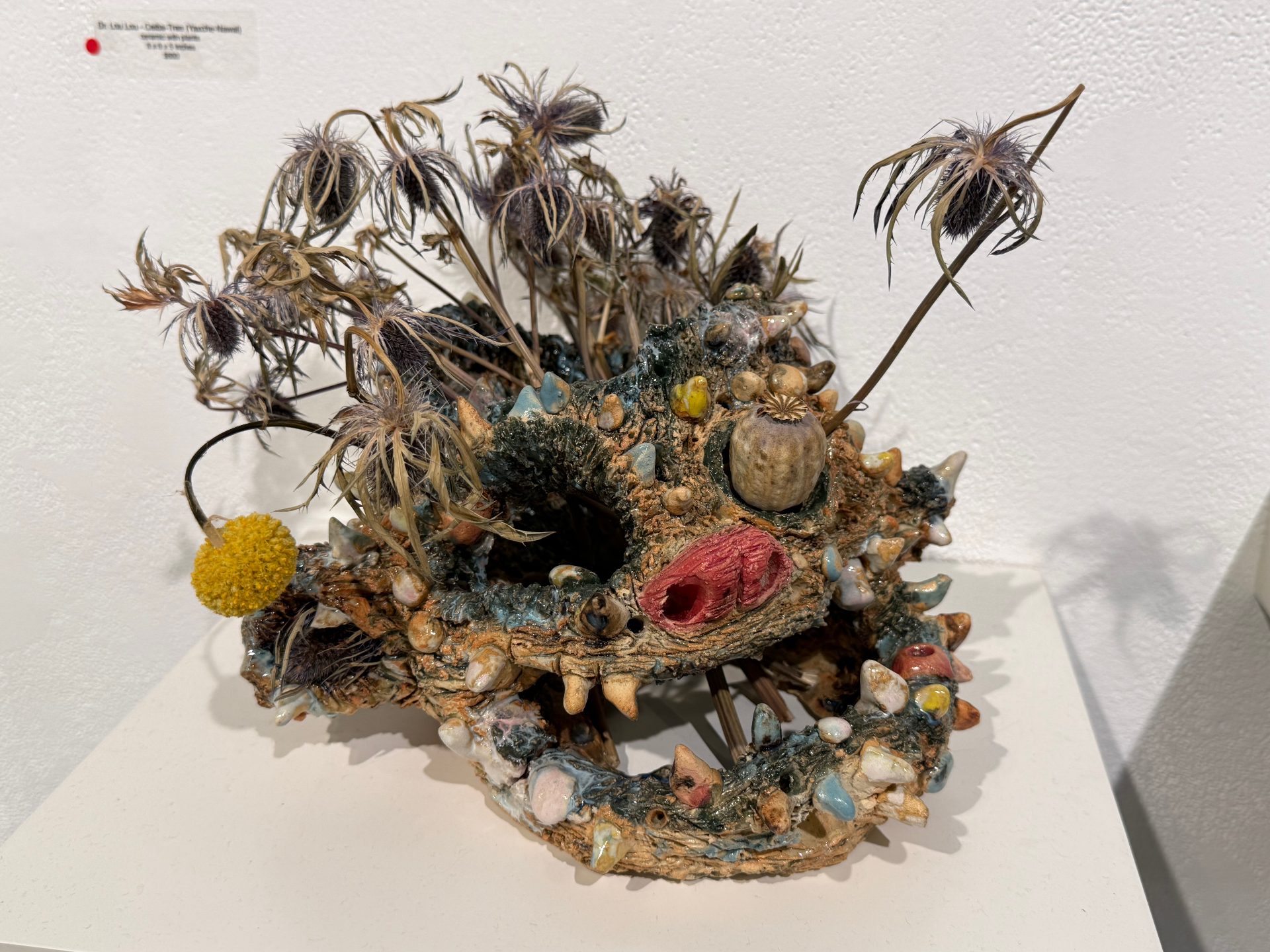 decaying ceramic face with real dead flowers coming out of various places.