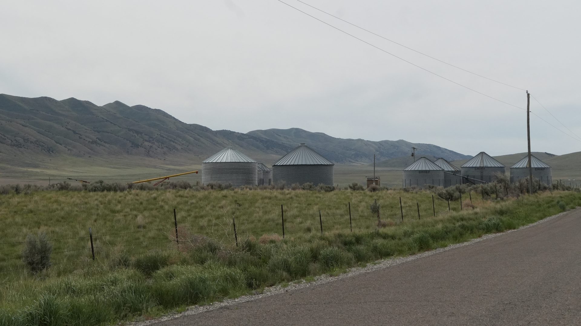 Short, squat grain silos with aluminum siding.