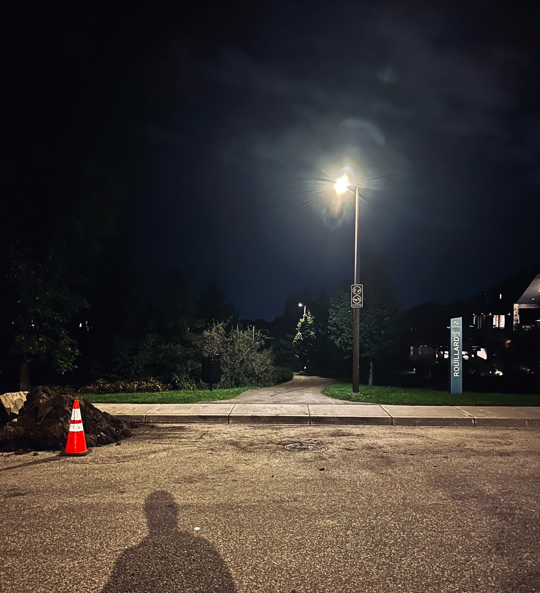 A street light in the distance on a road at night