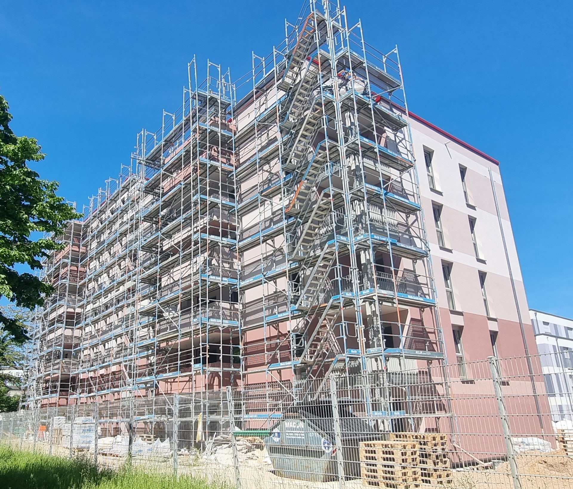 Eingerüsteter Neubau eines Mehrparteienhaus.