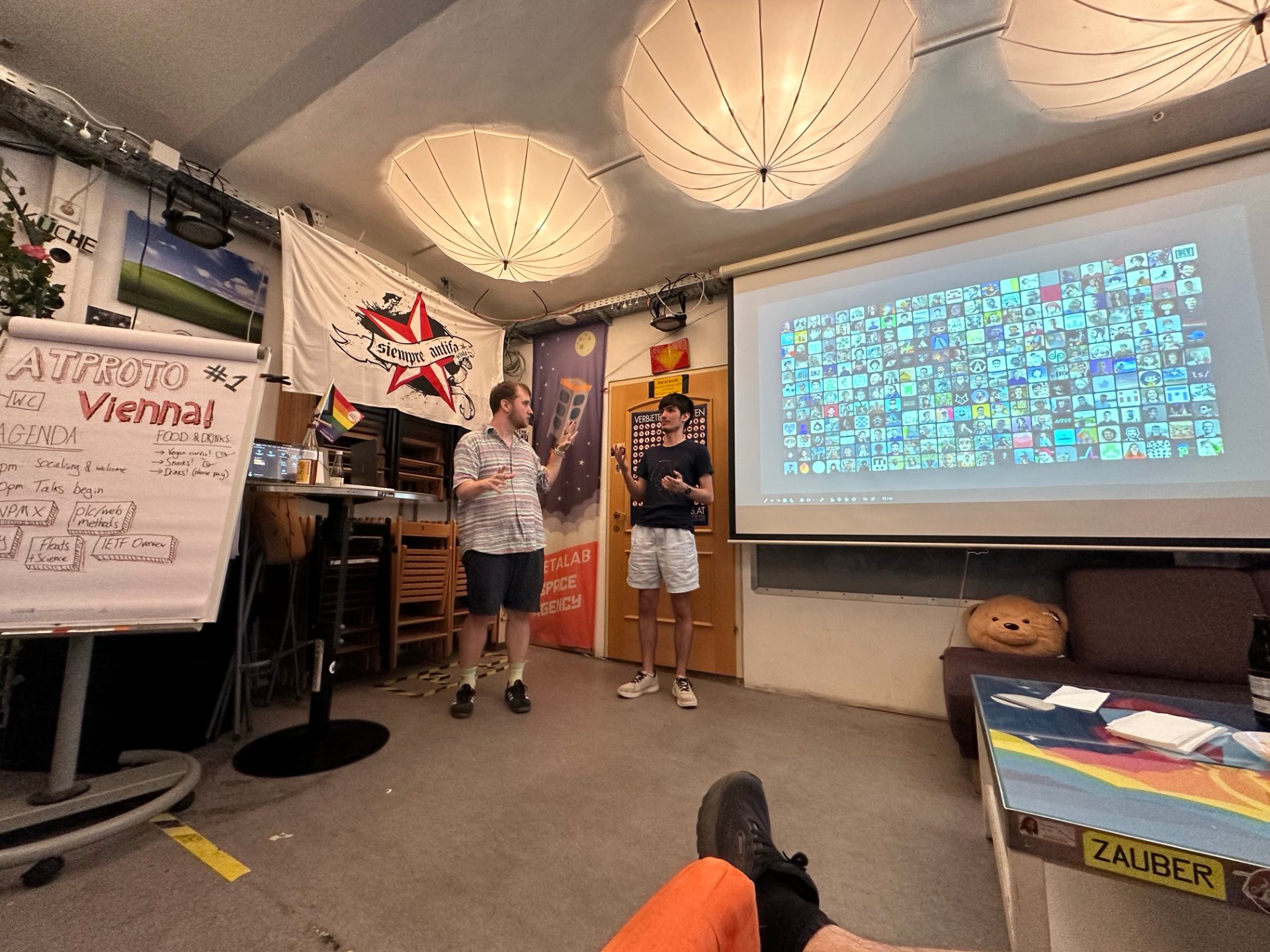 Mihai and Felix discussing atproto with the current slide showing the large community of contributors who have already joined the project.