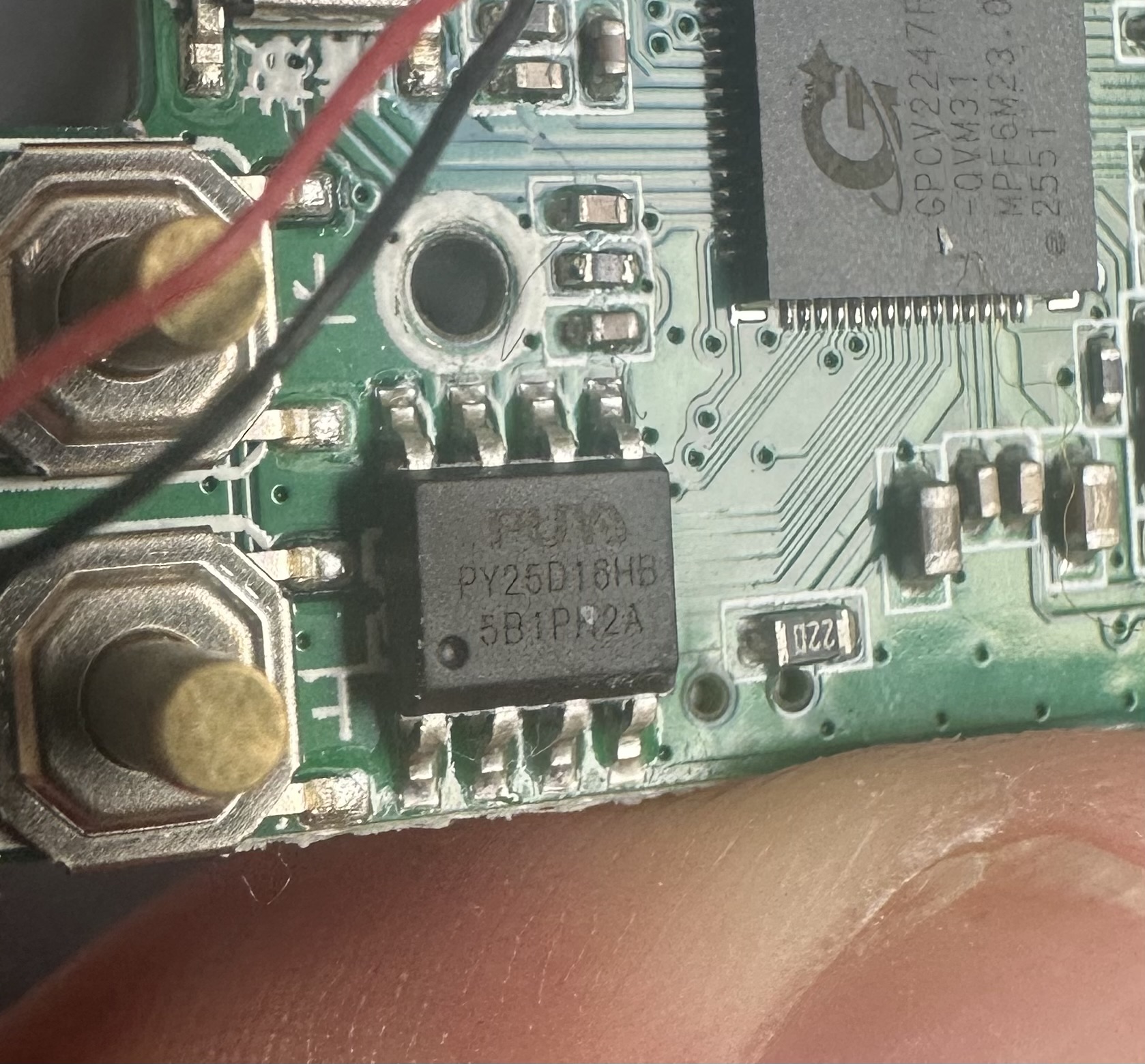 The tiny Puya chip, with the edge of my thumb holding the board. You could probably fit 6-8 of the Puya chips on my thumbnail.
