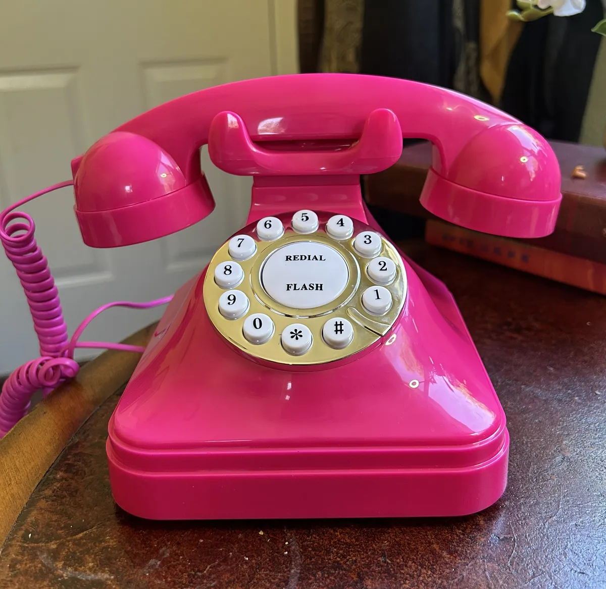 A bright pink, mock rotary corded phone.
