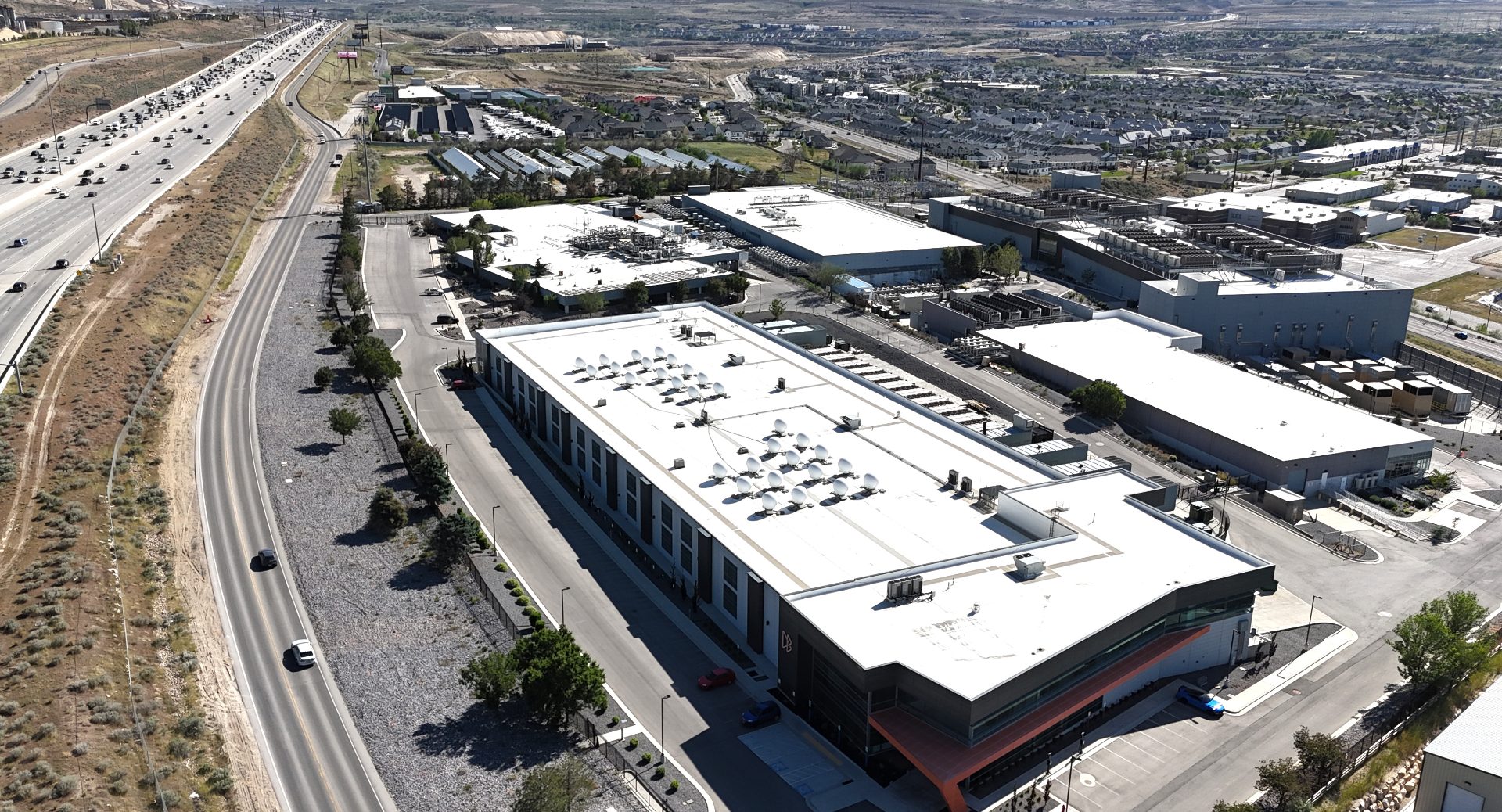 A datacenter campus, with five buildings, sits next to a busy freeway.
