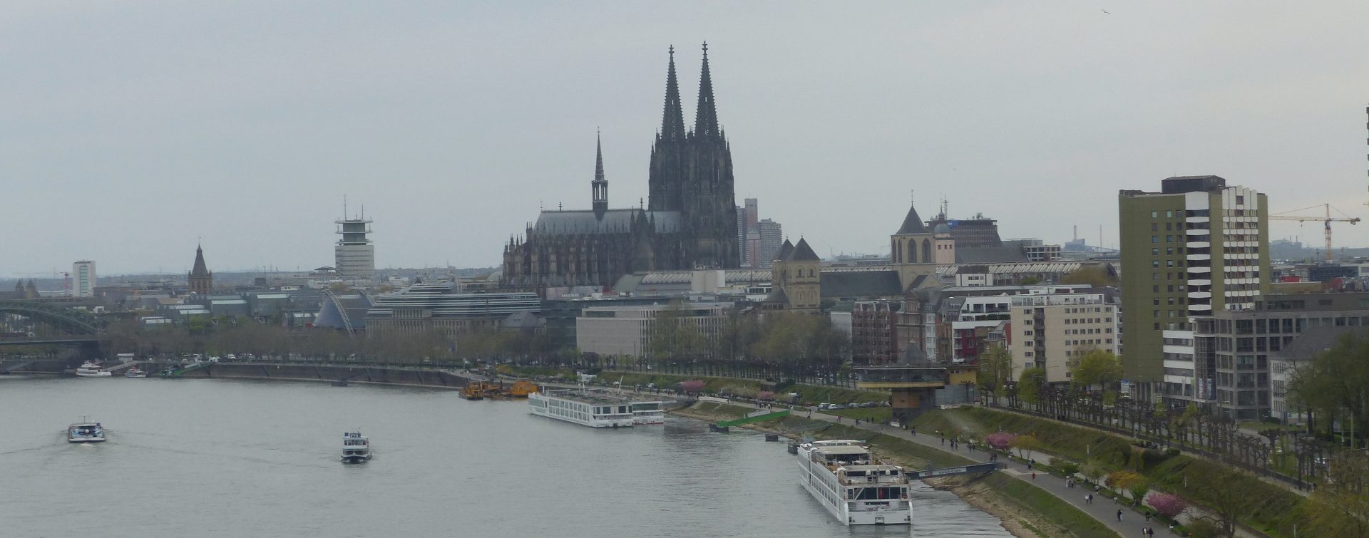 Blick auf das linksrheinische Panorama von Köln mit dem Rathausturm, Kölner Dom, St. Kunibert, der Bastei und dem Rhein.