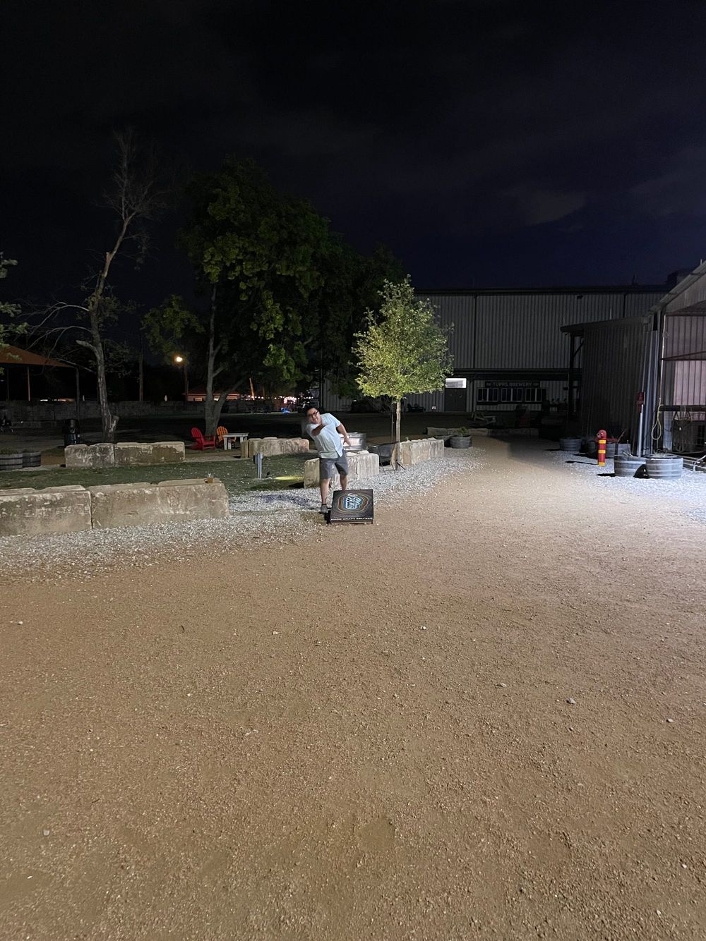 A guy throwing the sack in a corn hole game