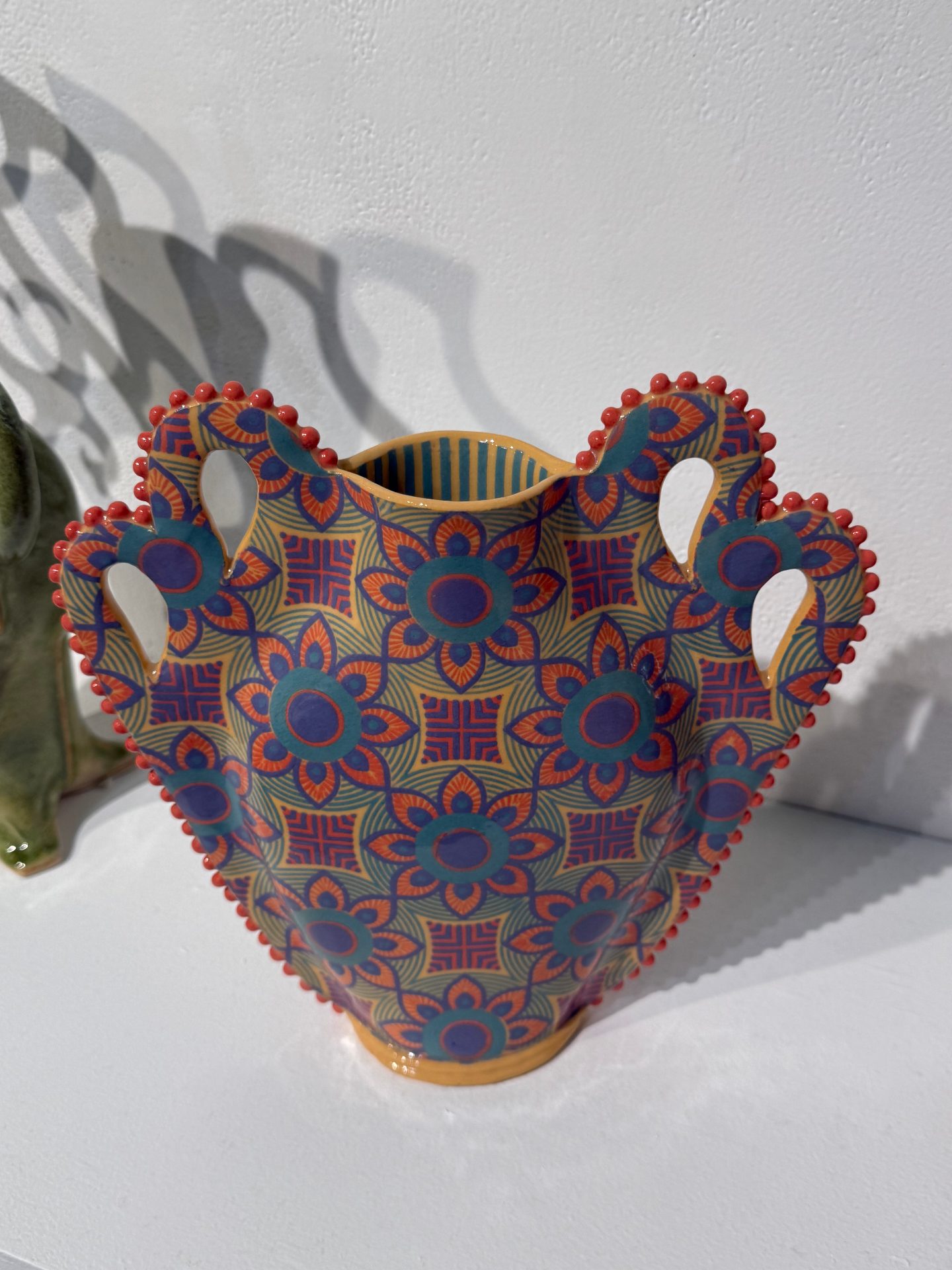 a colorful vase with intricate patterns of bright flowers